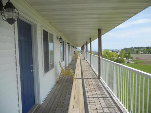 a porch of a house with a yellow bench on it at Coho Motel in Kewaunee