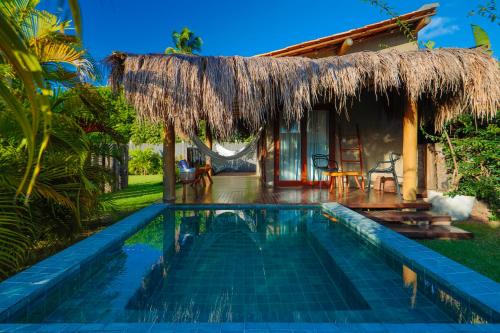 a resort with a swimming pool in front of a house at Pousada Tatuá in Pôrto de Pedras