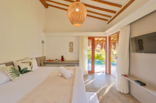 a living room with a white couch and a television at Pousada Tatuá in Pôrto de Pedras