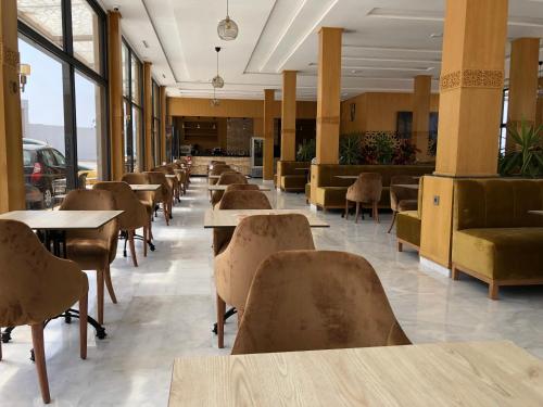 une rangée de tables et de chaises dans une cafétéria dans l'établissement Palm’s Motel, à Agadir