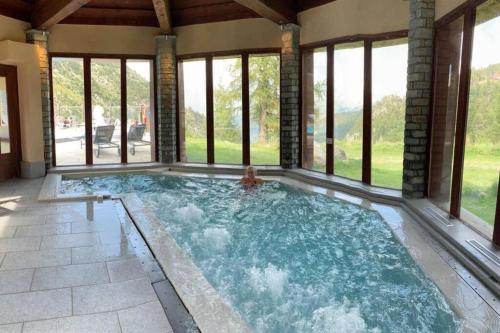 - une piscine dans une maison avec fenêtres dans l'établissement Arc 1950 2bdrm 6/8 guests Ski-in/out Pool+Jacuzzi, à Arc 1950