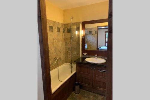 une salle de bain avec une baignoire et un lavabo et une baignoire tubermottermott dans l'établissement Arc 1950 2bdrm 6/8 guests Ski-in/out Pool+Jacuzzi, à Arc 1950