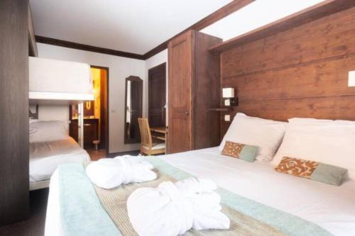 une chambre avec un lit avec des serviettes dessus dans l'établissement Arc 1950 2bdrm 6/8 guests Ski-in/out Pool+Jacuzzi, à Arc 1950