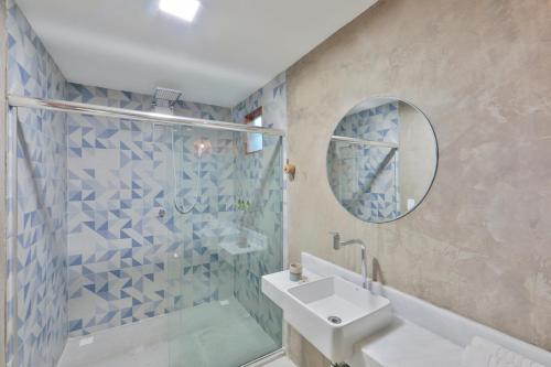 a bathroom with a shower and a sink and a mirror at Pousada Tatuá in Pôrto de Pedras