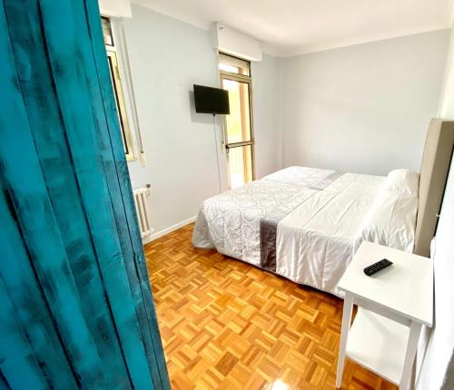a bedroom with a bed and a wooden floor at Garden Lodge Hostal Evencio in Ribadavia