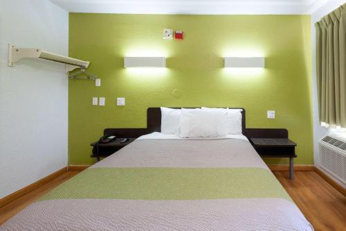 a bed in a room with a green wall at Motel 6-Camp Springs, DC - South Camp Springs in Camp Springs