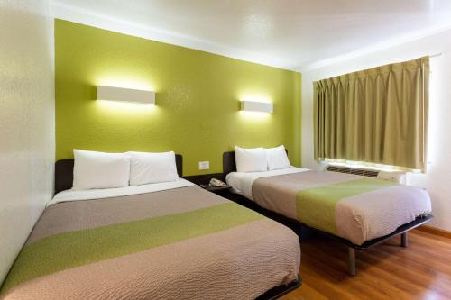 two beds in a room with green walls at Motel 6-Camp Springs, DC - South Camp Springs in Camp Springs
