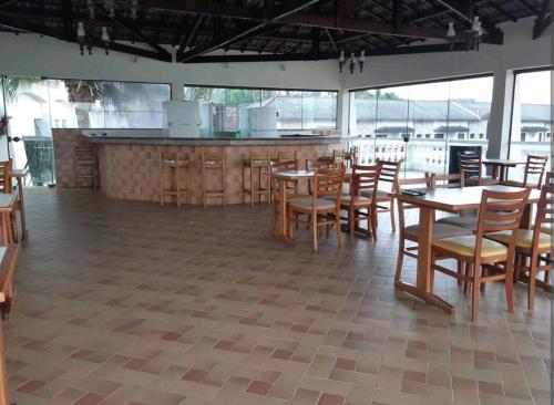 a restaurant with wooden tables and chairs and a counter at Flat encantador localizado no melhor de Serra Negra - SP in Serra Negra