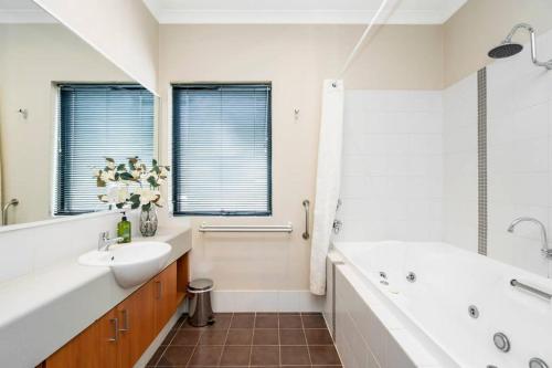 a bathroom with a white tub and a sink and a bath tub at 9 Fine Resort Rest 1br Spaparkingpool in Perth