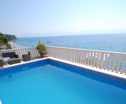 a swimming pool with a view of the ocean at Guesthouse Villa Paškal in Zaostrog