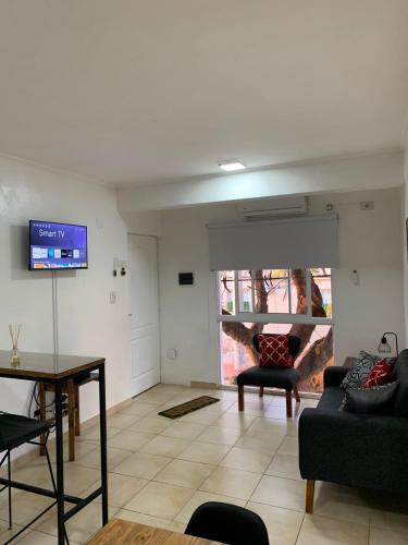 a living room with a couch and a tv at Departamentos Rodrigo in Posadas