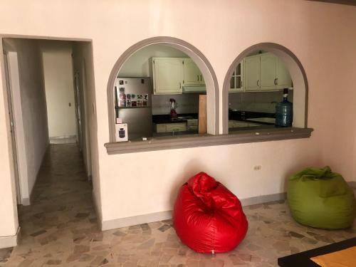 eine Küche mit zwei Torbögen und zwei roten Säcken in der Unterkunft Mini Hostal Cultural de Mazatlán in Mazatlán