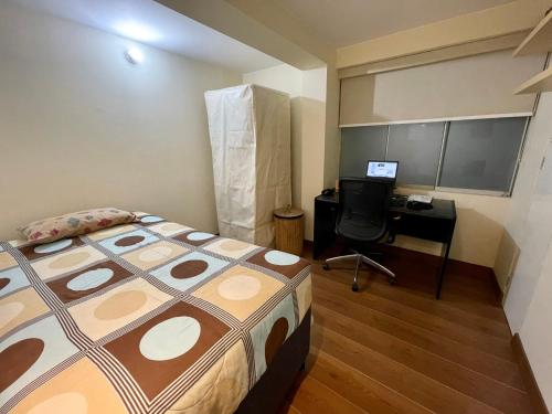 1 dormitorio con 1 cama y escritorio con ordenador en Like home, en Lima