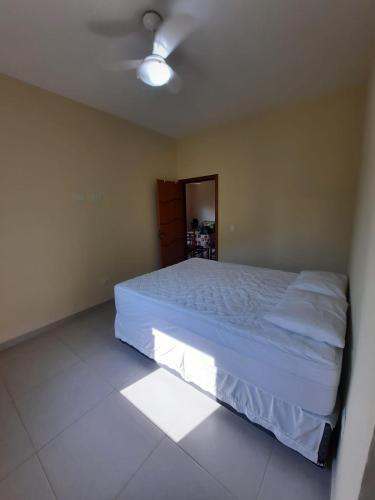 een slaapkamer met een groot wit bed in een kamer bij Lindo Apto Ubatuba a 300 metros Praia Sape in Ubatuba