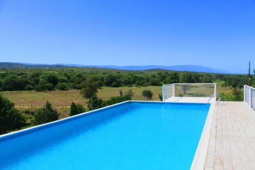 una piscina azul con vistas a las montañas en Cabañas y Toboganes Rancho la Ñata, en Mina Clavero
