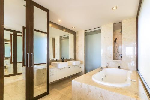 un ampio bagno con due lavandini e una vasca di Santai Sands - with Sea and Mountain Glimpses! a Casuarina