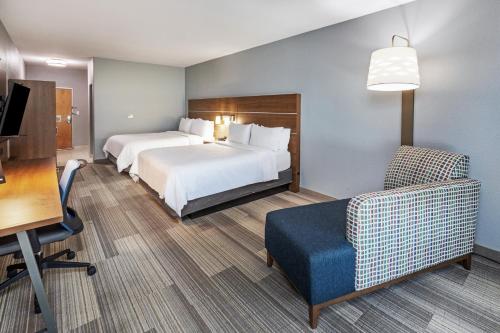 a hotel room with a bed and a chair at Holiday Inn Express Hotel & Suites Austin NE-Hutto by IHG in Hutto