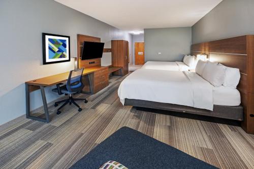 a hotel room with a bed and a desk with a computer at Holiday Inn Express Hotel & Suites Austin NE-Hutto by IHG in Hutto
