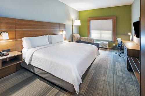 a hotel room with a large bed and a desk at Holiday Inn Express Hotel & Suites Austin NE-Hutto by IHG in Hutto
