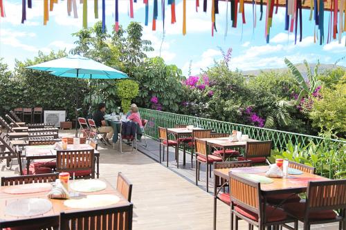 a patio area with tables, chairs and umbrellas at Hotel Casa de la Tía Tere in Oaxaca City