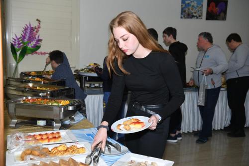 a woman holding a plate of food at a buffet at Continental Inn Hotel Al Farwaniya in Kuwait