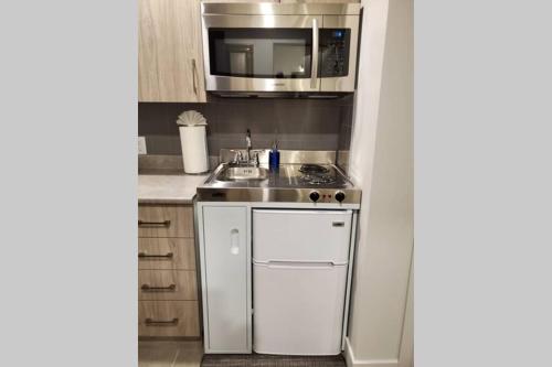a small kitchen with a sink and a microwave at Cozy Sweet Studio #7, 10 minutes to D.T. Ottawa in Gatineau
