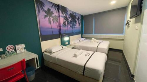 una camera d'albergo con due letti e una scrivania di Smile Hotel Chow Kit PWTC a Kuala Lumpur
