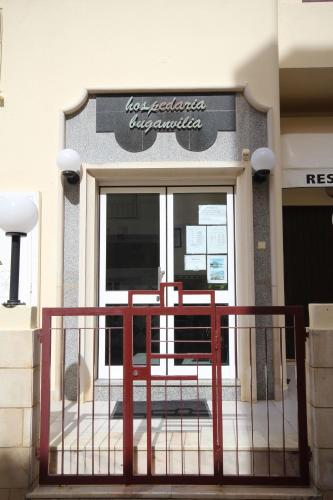 a front door of a restaurant with a sign on it at Hospedaria Buganvilia Alvor in Alvor