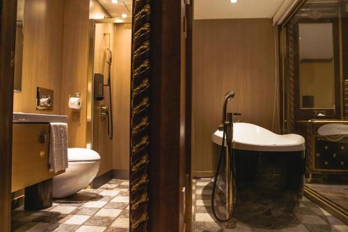 a bathroom with a tub and a toilet and a sink at Songdo Central Park Hotel in Incheon