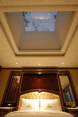 a bedroom with a bed with a painting on the ceiling at Songdo Central Park Hotel in Incheon