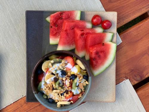 a bowl of salad and fruit on a plate at Voyaca Hotel Alfareria in Villa de Leyva