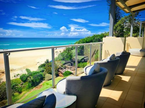 a balcony with chairs and a view of the beach at The Beach Cabarita in Cabarita Beach