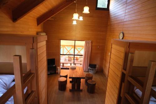 a room with a wooden table and bench in a cabin at フォレストコテージ奥州 in Oshu