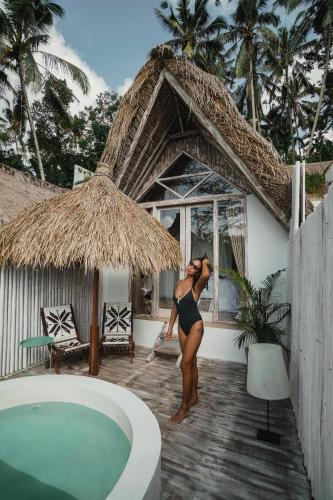 a woman in a black bikini standing next to a swimming pool at Woywoy Escape Bresela Adults Only in Tegalalang