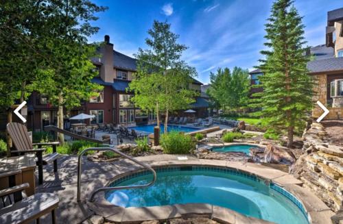 a swimming pool in a yard with a resort at Ski in Ski out Resort Breckenridge 1BR 2Beds Parking, Resort Shuttle & Amenities in Breckenridge