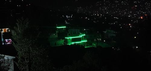 a house with green lights on it at night at Srinagar Homes in Muzaffarabad