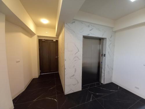 a hallway with a marble wall and a door at 航空棧輕旅民宿 in Huxi