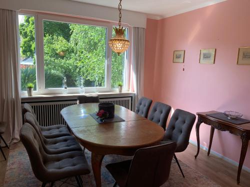 comedor con mesa, sillas y ventana en Villa Hortensie en Aquisgrán