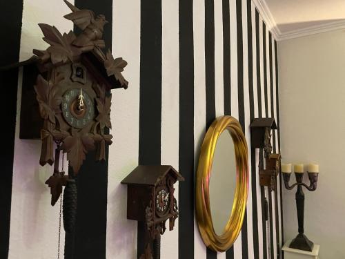 Hotel Am Volksgarten في دوسلدورف: ساعة ومرآة على الحائط