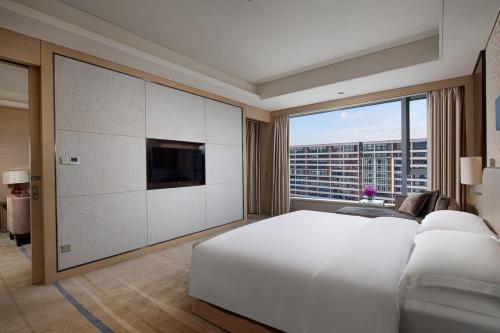 una camera da letto con un grande letto bianco e una grande finestra di Crowne Plaza Guangzhou Huadu, an IHG Hotel - Free shuttle bus to Baiyun airport a Canton