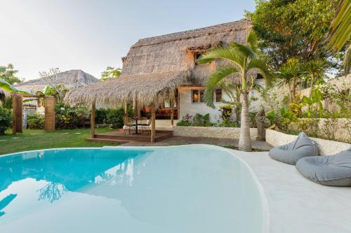 a villa with a pool in front of a house at Le Yanandra Bali Resort in Jimbaran