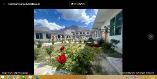 uma imagem de uma casa com rosas vermelhas em Hotel Sarfaranga & Restaurant em Ranga