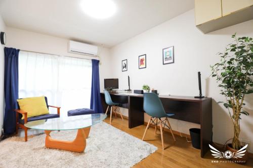 a living room with a desk and a table at Minoshima Apartment 401 in Fukuoka