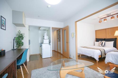 a room with a bed and a kitchen with a table at Minoshima Apartment 401 in Fukuoka