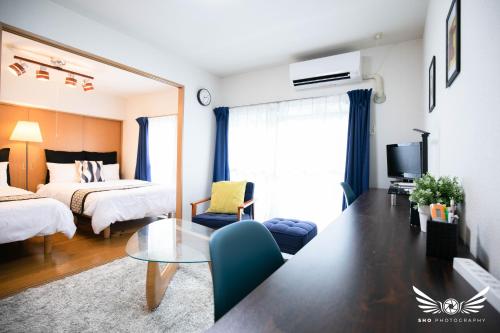 a living room with a bed and a table in a room at Minoshima Apartment 401 in Fukuoka