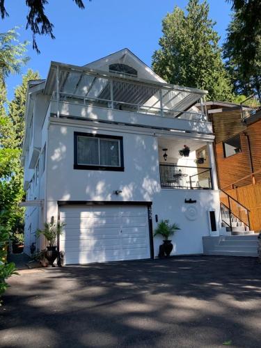 a white house with a white garage door at Beautiful Two Bedroom Suite in North Vancouver