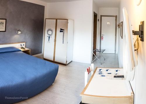 a bedroom with a bed and a door with a clock on it at Hotel Giardino in Breno