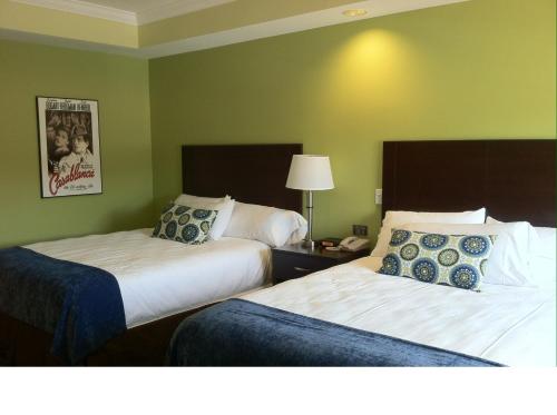 two beds in a hotel room with green walls at Starlight Inn in Burlington