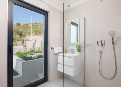 a bathroom with a shower and a sink and a mirror at Villa Ocean View I Zatoglav in Rogoznica