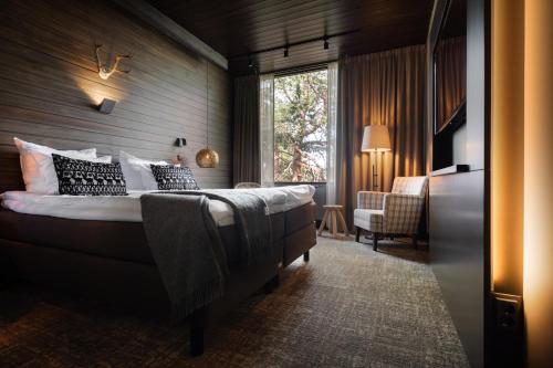 a bedroom with a bed and a large window at Lapland Hotels Sky Ounasvaara in Rovaniemi